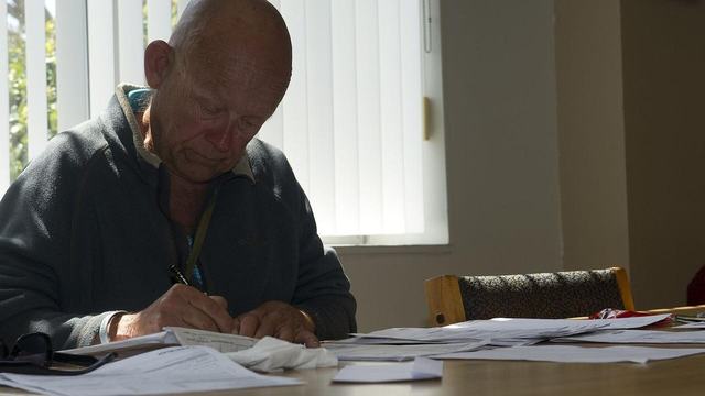 A man filling in paperwork at a table