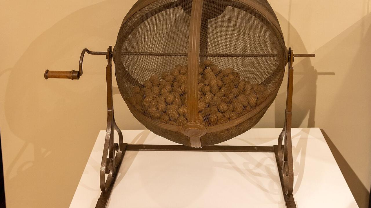 An old drawing drum with a hand crank, the kind used to pick winning entries